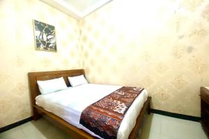 een kleine slaapkamer met een bed in een kamer bij Capital O 93942 Griya Singgah Berkah Syariah in Purworejo