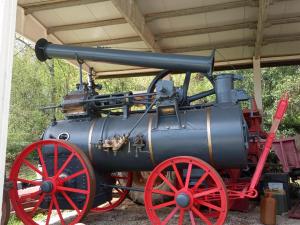 una vieja máquina de vapor expuesta bajo un edificio en Az.Agricola Agriturismo La Locanda di LANN, en Fucecchio