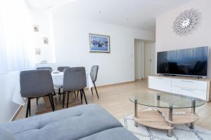 sala de estar con mesa, sillas y TV en Apartment Satureja Montana, en Split