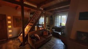 een woonkamer met een bank en een houten trap bij Dzikie wino in Budry
