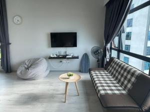 a living room with a couch and a tv at Loveable Home JESSELTON QUAY NEAR SURIA SABAH 亞庇晴文旅 in Kota Kinabalu