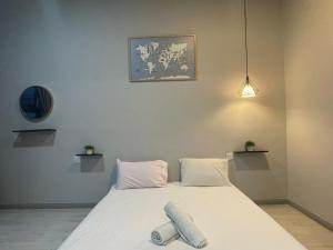 łóżko z białą pościelą i poduszkami w pokoju w obiekcie Loveable Home JESSELTON QUAY NEAR SURIA SABAH 亞庇晴文旅 w mieście Kota Kinabalu