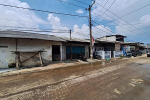 an old building on a street with a dirt road at SPOT ON 93908 Angel Guest House in Tangerang