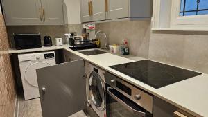 a kitchen with a stove top oven next to a washing machine at Apartment London Eye Big Ben walk to China town in London