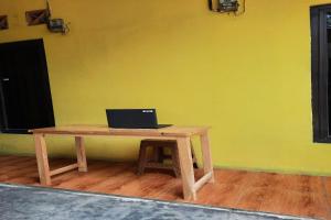 a laptop computer sitting on a wooden table in a room at SPOT ON 93908 Angel Guest House in Tangerang