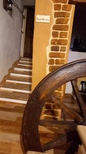 eine Treppe mit einer Ziegelwand und einem Holzrad in der Unterkunft Un Tuffo nel passato "B&B Santu Giuvanni" in Fonni