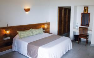 a bedroom with a bed and a desk and a chair at Le Saly Hotel & Hotel Club Filaos in Saly Portudal
