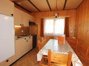 cocina con mesa de comedor y cocina con ventana en Modern Chalet in Saas Balen with Garden en Saas-Balen