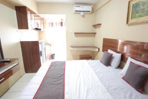 um quarto com uma cama grande num quarto em Super OYO Capital O 93910 Asia Rooms at Green Lake View Ciputat em Tangerang