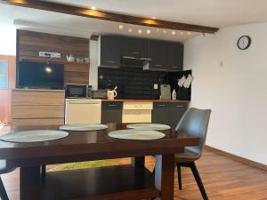 a kitchen with a table and chairs and a kitchen with black cabinets at Kawalerki w Śródmieściu 1 in Bydgoszcz +1 photo