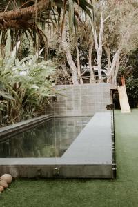 a swimming pool in a garden with grass and trees at Gorgeous 5 bedroom beach house. Dog/Kid Friendly. in Marcoola