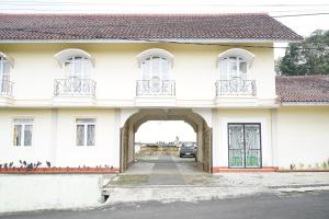 ein weißes Haus mit Torbogen in der Unterkunft Capital O 93949 Hotel Popuci By Pupa Hospitality in Kuningan