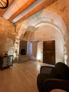 a large room with a fireplace and a wooden door at Ortahisar Cave Hotel in Ortahisar