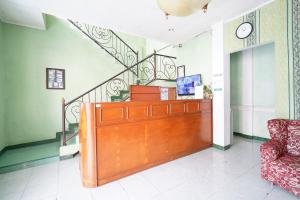 ein Wohnzimmer mit einem Schreibtisch und einer Treppe in der Unterkunft Capital O 93949 Hotel Popuci By Pupa Hospitality in Kuningan