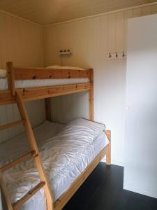 a bunk bed room with two bunk beds in it at Ulvsvåg Gjestgiveri og Fjordcamping AS in Ulvsvåg