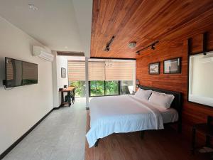 a bedroom with a bed and a flat screen tv at Hailin Resort Vangvieng in Vang Vieng