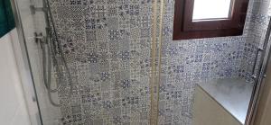 a bathroom with a shower with blue and white tiles at Sa Frummiga in Cagliari