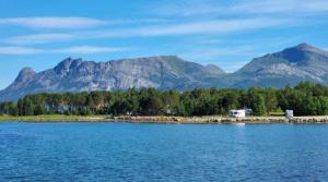 a view of a lake with mountains in the background at Ulvsvåg Gjestgiveri og Fjordcamping AS in Ulvsvåg