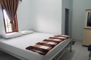a bed in a room with a window at OYO 93951 Family Guesthouse in Medan
