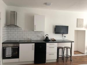 a kitchen with white cabinets and a black counter top at Studio in Bolton town, Short stay studio 4 in Bolton