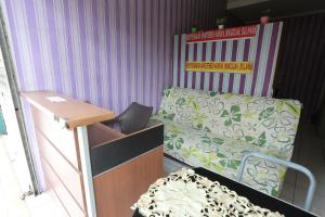 a room with a bed and a desk with a chair at OYO 93952 Dms Property in Bekasi