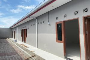 un bâtiment blanc avec une porte sur son côté dans l'établissement OYO 93951 Family Guesthouse, à Medan