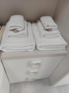 a white towels are sitting on a shelf in a bathroom at Appartamento Mari Mari in Casale Monferrato