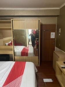 una persona que toma una foto de una cama en una habitación en OYO 93952 Dms Property, en Bekasi