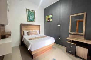 een slaapkamer met een bed en een televisie. bij Belvilla 93954 Meta Pandawa Bali Mounth Villa in Jembrana