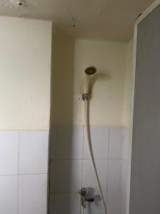 a shower head in a bathroom with a tiled wall at OYO 93952 Dms Property in Bekasi