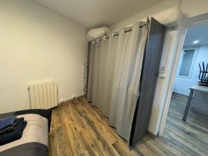 1 dormitorio con cama y cortina de ducha en Appartement cosy, en Roussillon en Isère