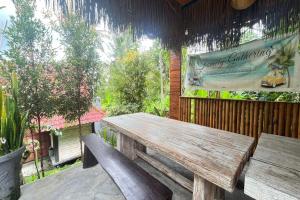 eine Holzbank auf einer Terrasse mit einem Schild in der Unterkunft Belvilla 93954 Meta Pandawa Bali Mounth Villa in Jembrana
