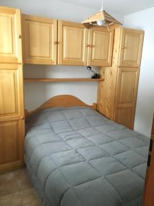 łóżko w pokoju z drewnianymi szafkami w obiekcie Ambiance montagne front de neige w mieście Thollon-les-Mémises
