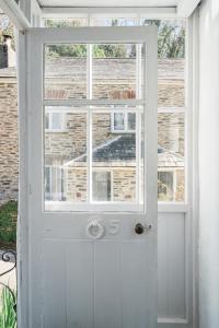 a white door with a window in front of it at Blue Cottage! Amazing views & Cosy Lux Interiors in Bodinnick