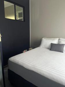 Schlafzimmer mit einem weißen Bett und einem Spiegel in der Unterkunft Shiloh Shared in Gaborone
