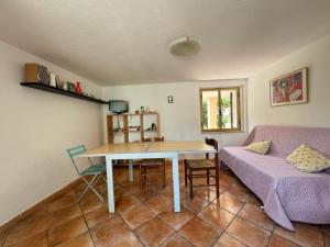 uma sala de estar com uma mesa e um sofá em PM 5 Via Del Cisto Guest House em S'archittu Cuglieri