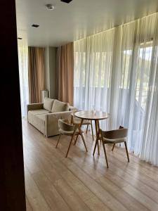 salon z kanapą, stołem i krzesłami w obiekcie SAVOIE Apartments Bukovel w mieście Bukowel