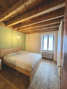 una camera con un grande letto e una finestra di Casa Smitt ad Alagna Valsesia