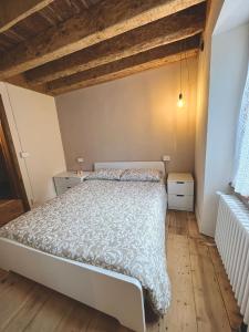 1 dormitorio con 1 cama y suelo de madera en Casa Smitt, en Alagna Valsesia