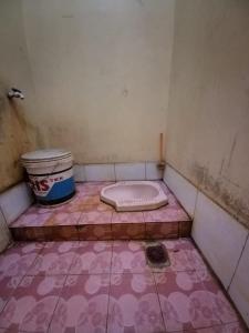a room with a pink floor and a toilet in it at SPOT ON 93956 Siliwangi Guest House Syariah in Bandung