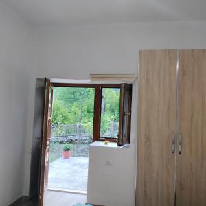 eine Küche mit einem Kühlschrank und einem Fenster in der Unterkunft Stomici Guesthouse in Ndërlysaj