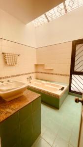 uma casa de banho com uma banheira e um lavatório em Namma Ashram em Bangalore