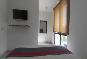 a bedroom with a bed with a flat screen tv at OYO 93958 J&B Smart Jatinegara in Jakarta