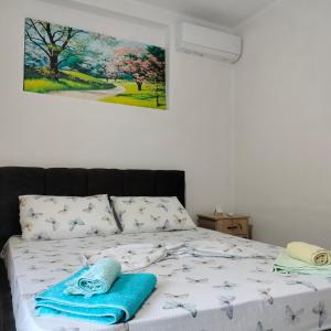 ein Schlafzimmer mit einem Bett mit blauen Handtüchern darauf in der Unterkunft Stomici Guesthouse in Ndërlysaj