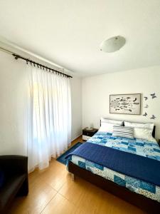 Schlafzimmer mit einem Bett mit blauer Decke in der Unterkunft Apartment Kontrada in Umag