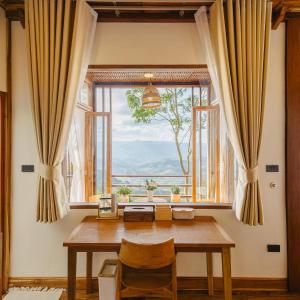 a dining room with a table and a large window at U AND ME 6395 DOICHANG in Ban Huai Khai