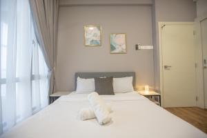 een slaapkamer met een groot wit bed en handdoeken bij Duplex at Arte Mont Kiara by Bai Yi # 2501 in Kuala Lumpur