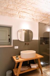 a bathroom with a sink and a mirror at Trullo Jalè - Boutique Apartments in Ostuni