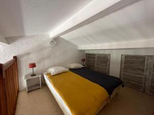 ボルム・レ・ミモザにあるSuperbe Duplex 35m2 vue mer avec piscineのベッドルーム1室(大型ベッド1台、黄色い毛布付)