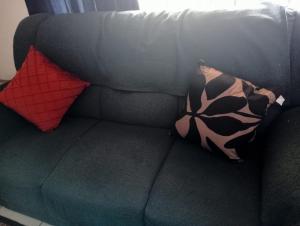 a couch with two pillows on top of it at Villa del Sol Margate in Margate